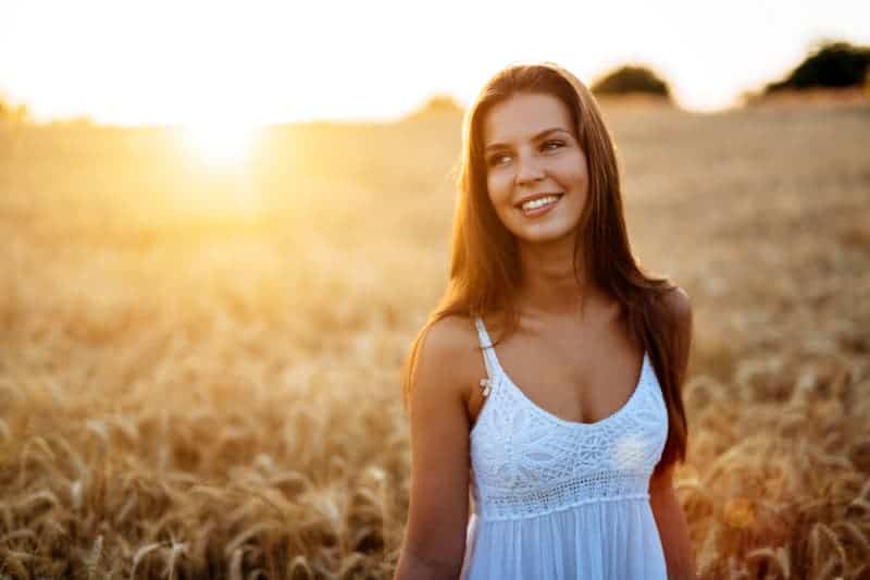 ung le kvinna i fält med solnedgång