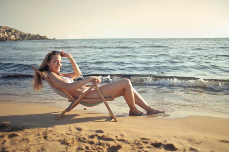 kvinna på stranden i solstol
