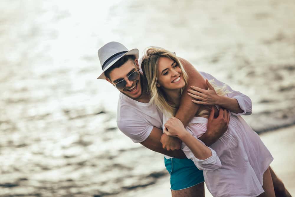 Romantiska par som har gyckel på stranden