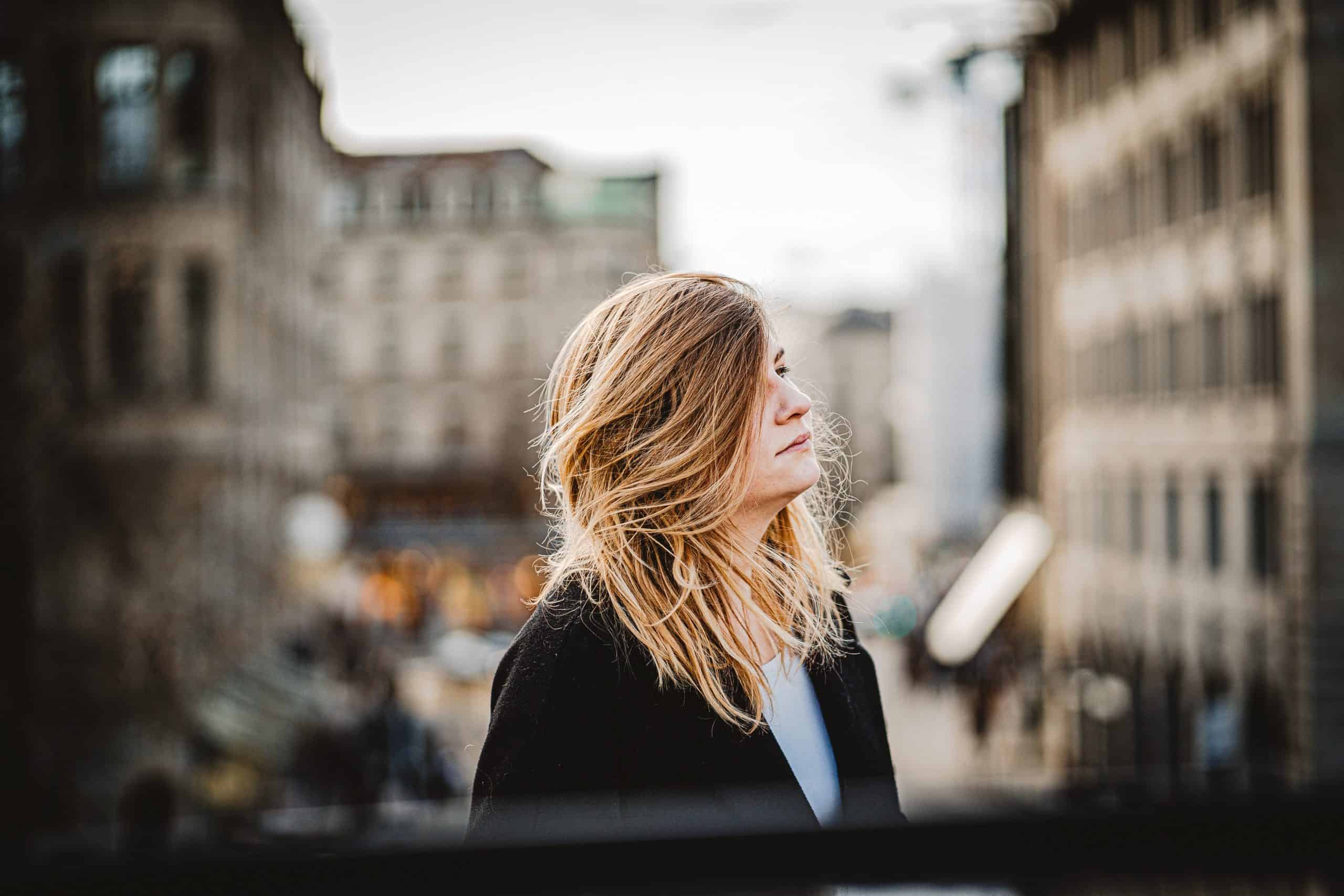 blond kvinna som tittar på avstånd i staden