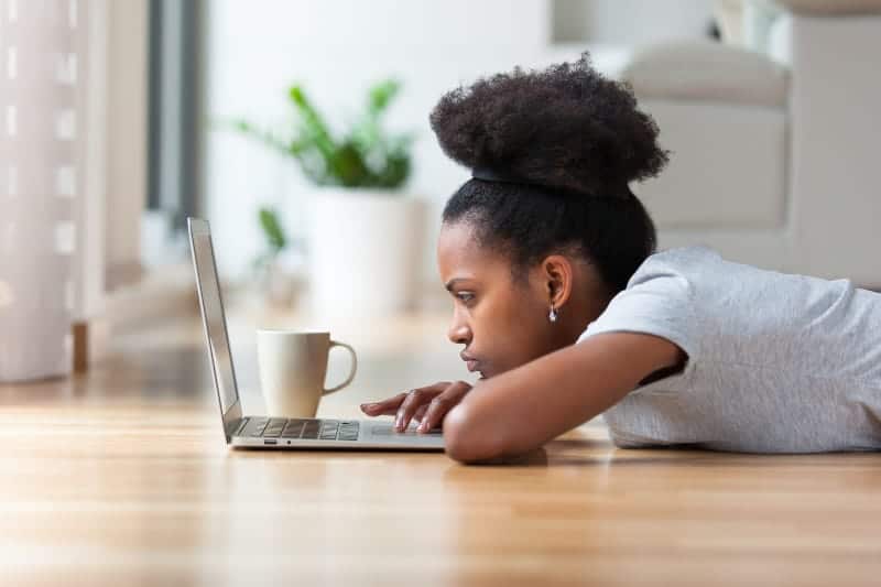kvinna med kaffe tittar på laptop