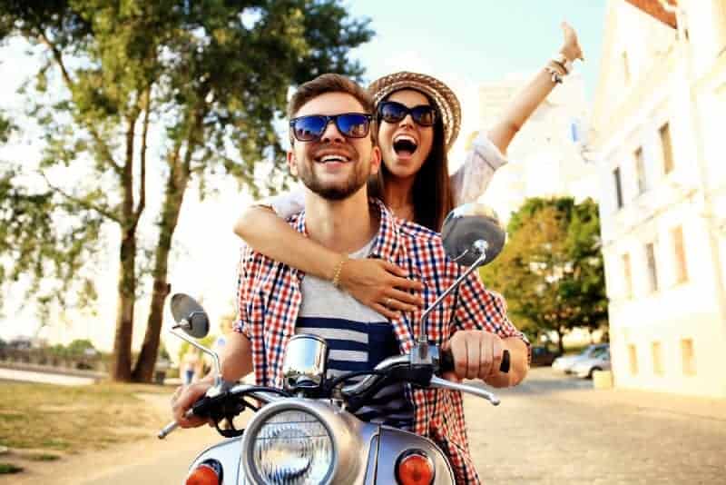 lyckliga par som rider på en motorcykel