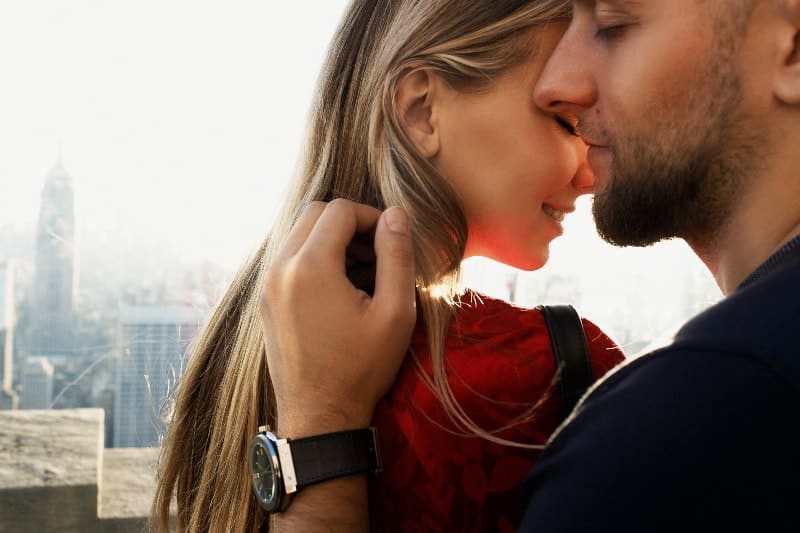 man och kvinna njuter av ett romantiskt ögonblick på stadens tak
