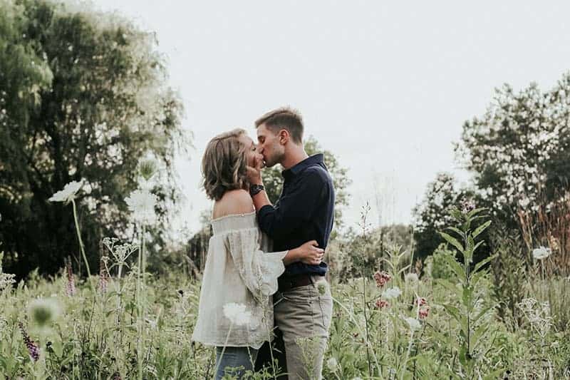 man och kvinna som kysser i fält