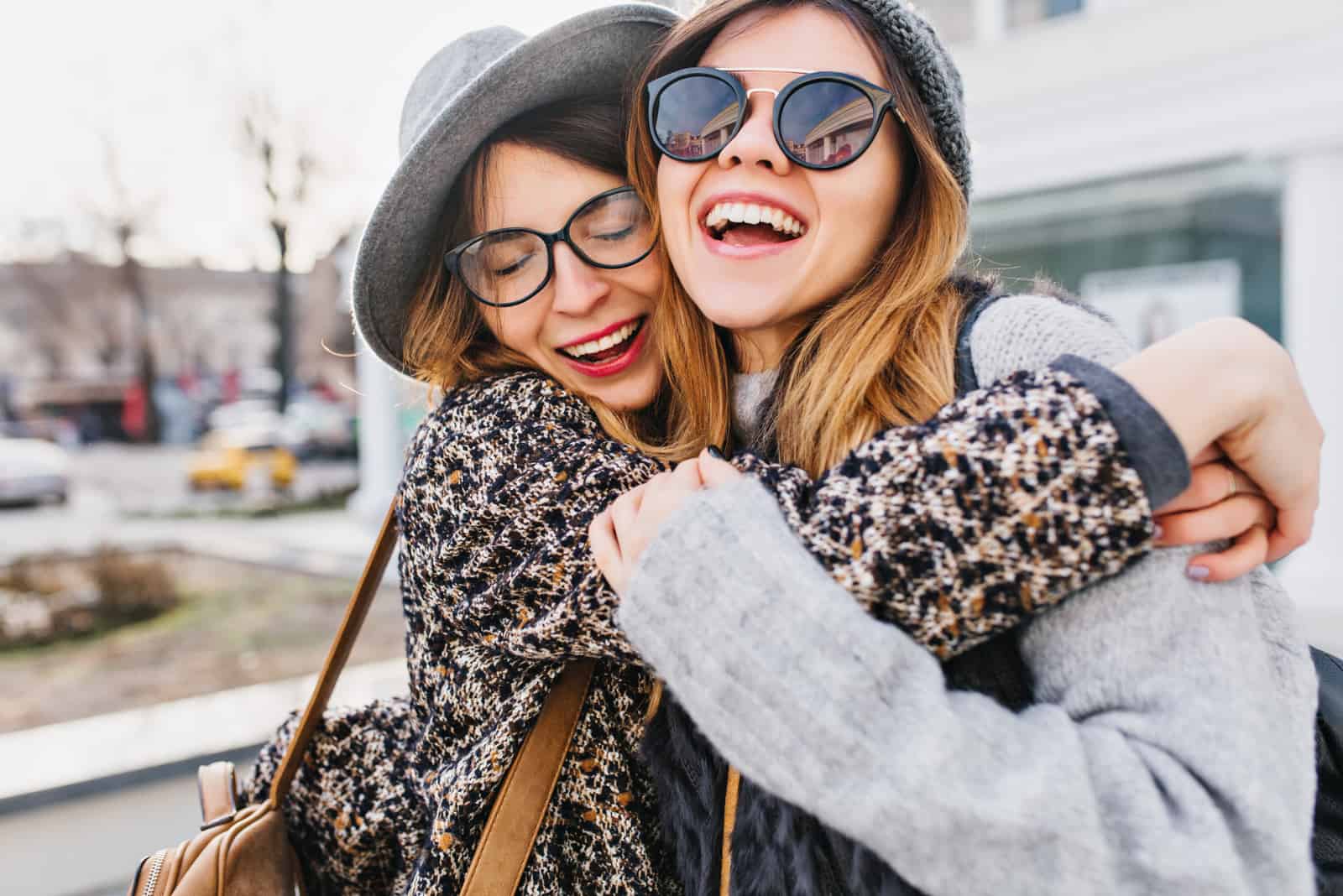 två leende tjejer som kramar utanför