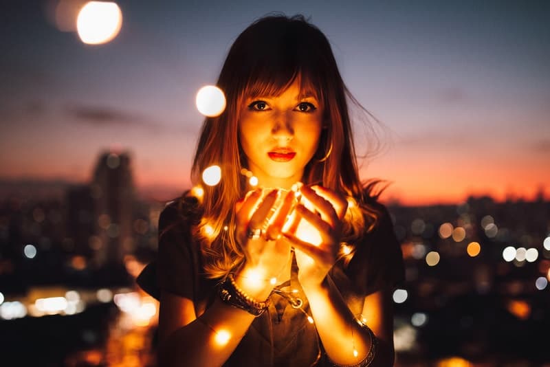ett porträtt av en flicka som håller dekorativa ljus i sina händer