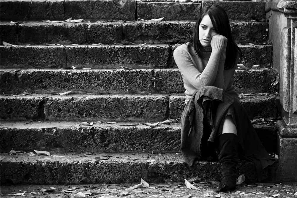 ung ledsen kvinna som sitter på trappan