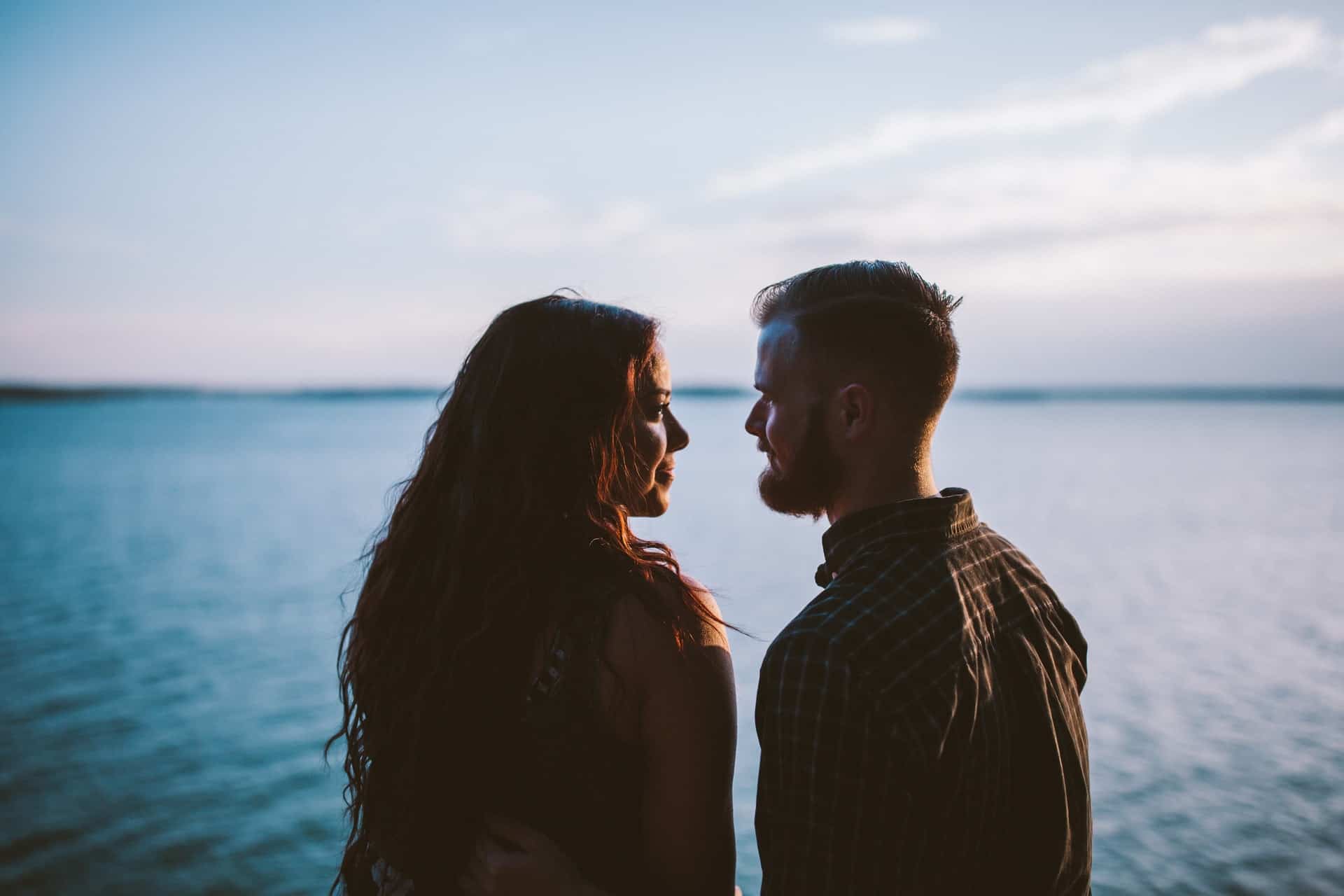 en man och en kvinna tittar på varandra vid havet
