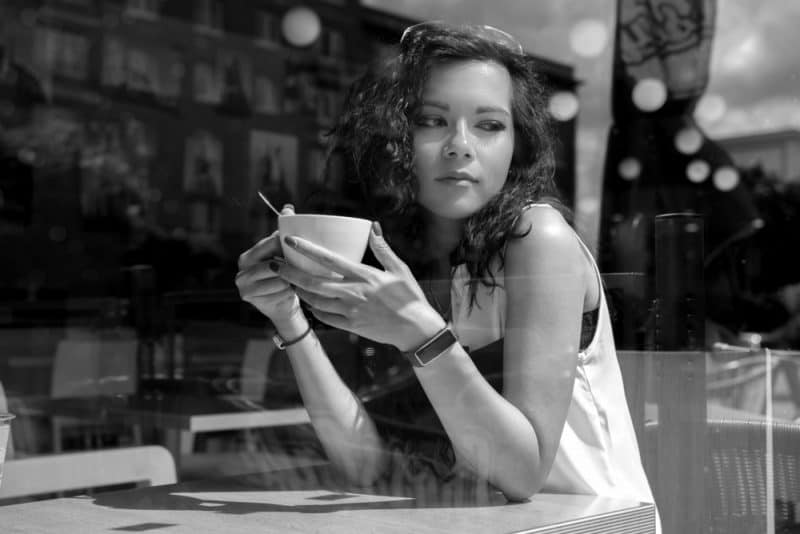 kvinna som dricker kaffe på ett kafé