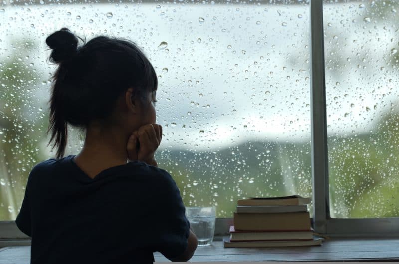 ung kvinna som tittar genom fönstret
