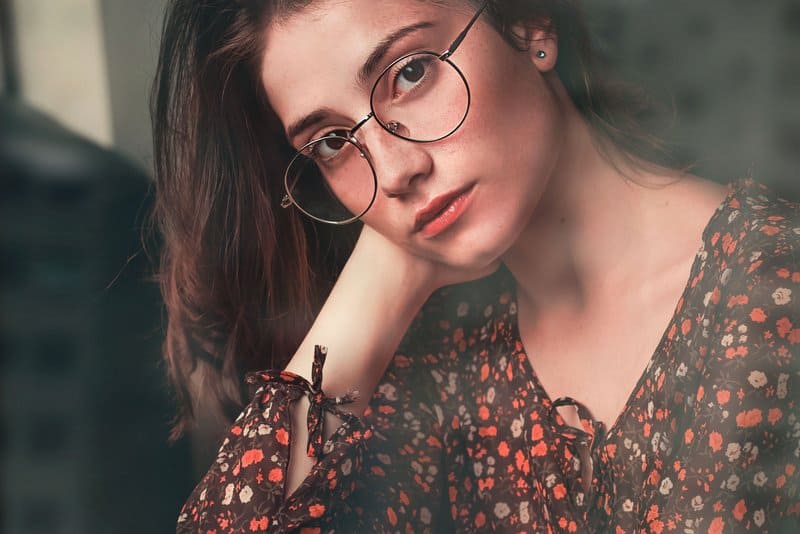 porträtt av en vacker allvarlig flicka med glasögon