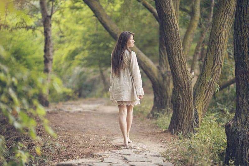 kvinna som går ensam i skogen