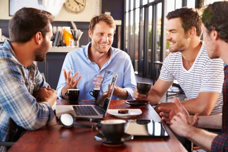fyra män ler och pratar
