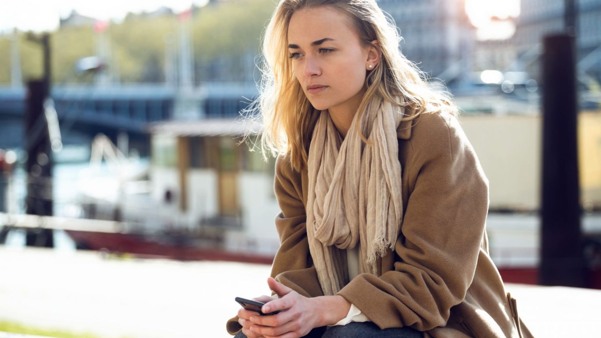 fundersam och ledsen blond kvinna som sitter ensam