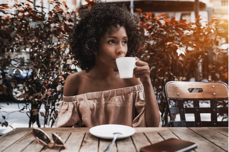 kvinna sitter på café dricka kaffe