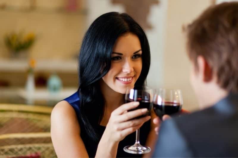 man och kvinna dricker vin på datum