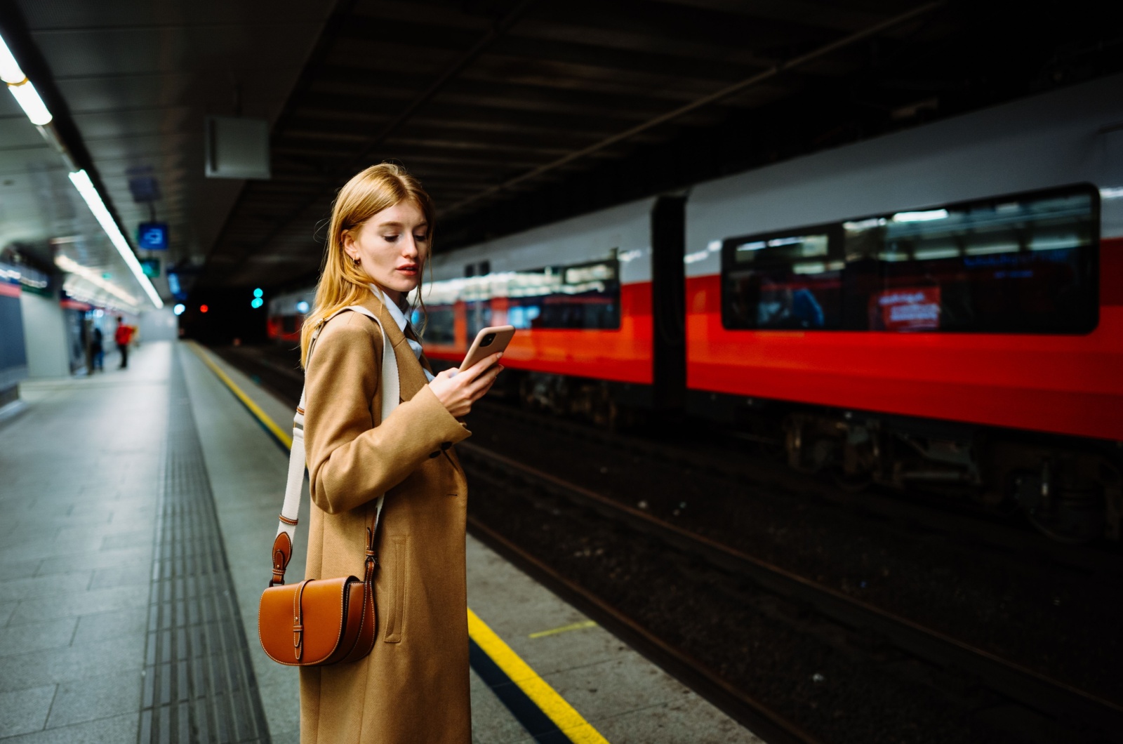Frau haelt ein Telefon in der U-Bahn Frau haelt ein Telefon in der U-Bahn