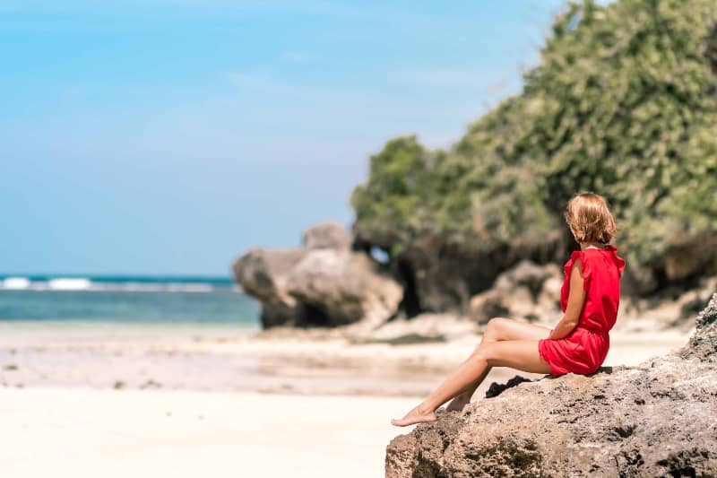 ein Mädchen beobachtet den Strand und sitzt auf einem Felsen(1) ein Mädchen beobachtet den Strand und sitzt auf einem Felsen(1)