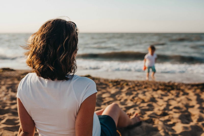 eine Frau, die ein Kind am Strand beobachtet(1) eine Frau, die ein Kind am Strand beobachtet(1)