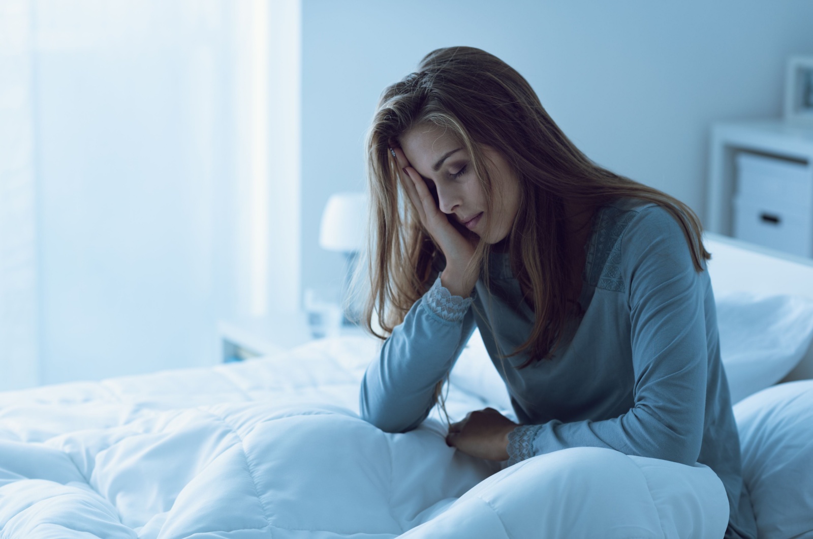 frau sitzt mueede im bett frau sitzt mueede im bett