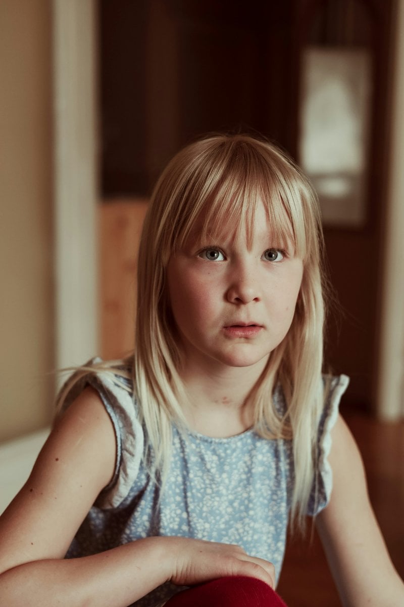 A little girl sitting on the floor with a stuffed animal ...