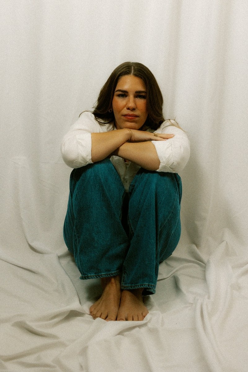 A sad woman sits alone with her arms crossed. photo &ndash; Free Purple Image on  Unsplash