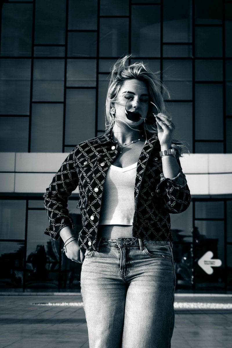 A young woman in sunglasses and jeans stands outside. photo &ndash; Free Fashion  model Image on Unsplash