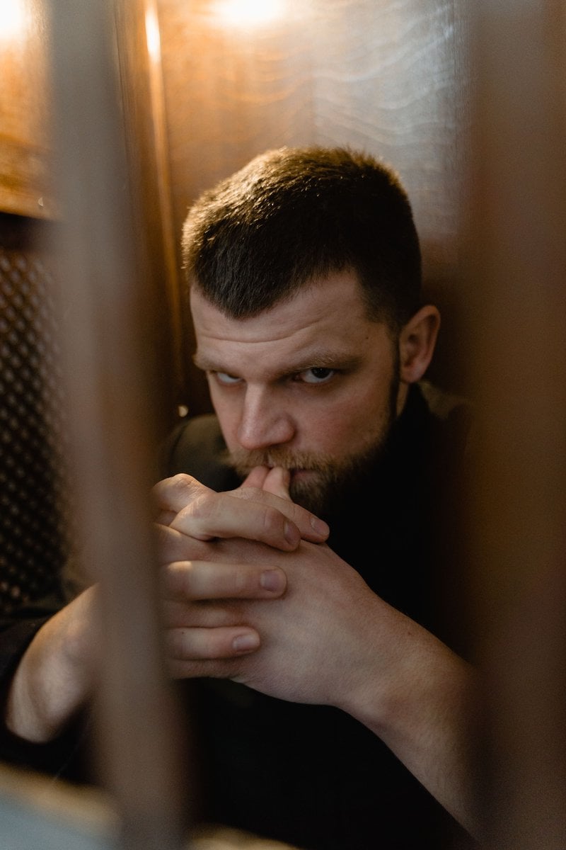 An Angry Man in Black Jacket Standing Behind Metal Bars &middot; Free Stock Photo