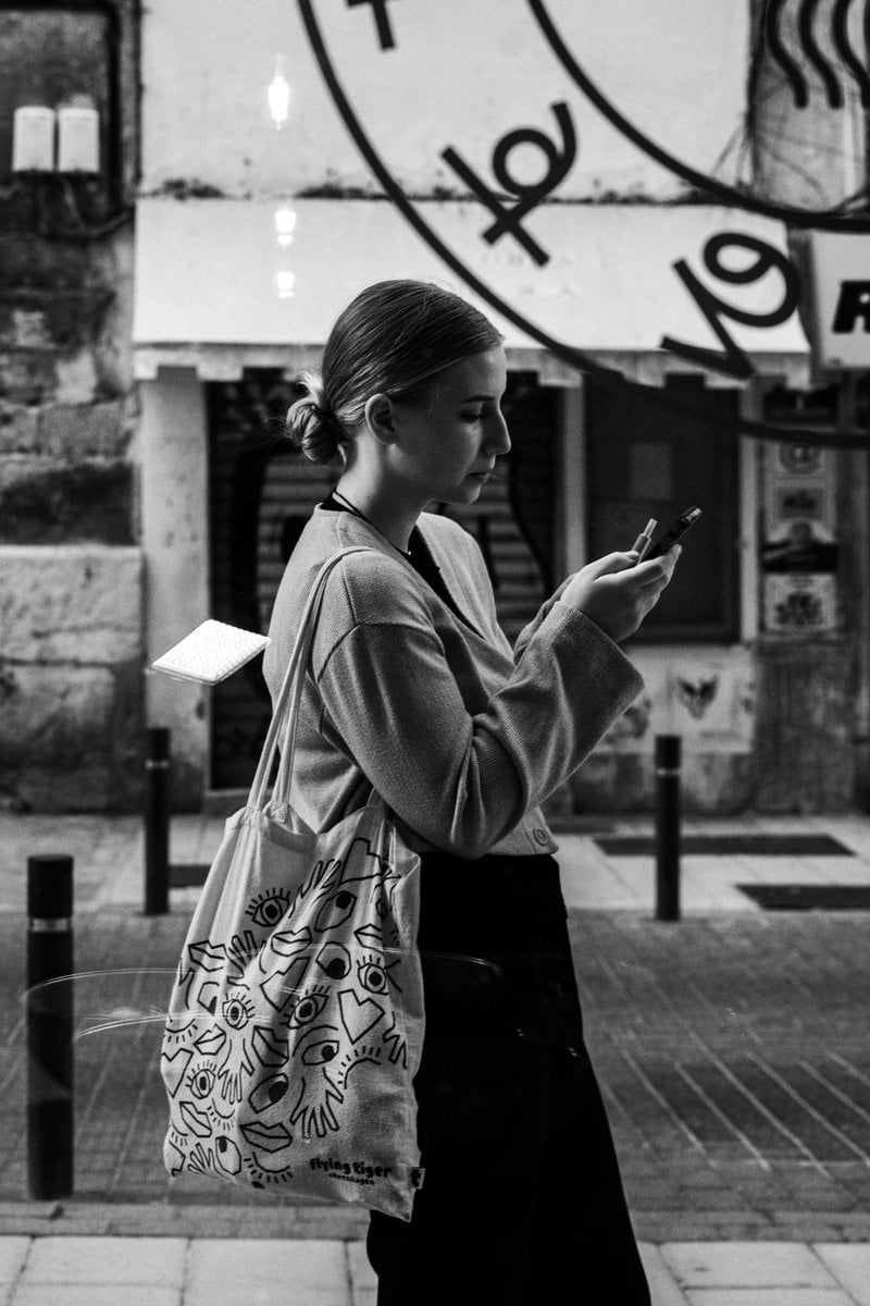 Black and White Shot of a Woman Checking her Smartphone in the Street &middot;  Free Stock Photo