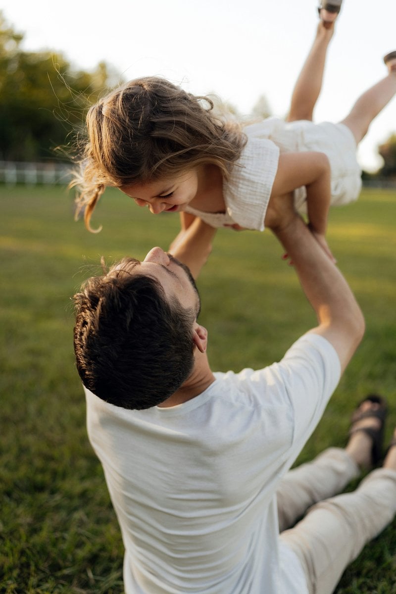 Father throwing his laughing daughter in the air - Free Photo on Unsplash