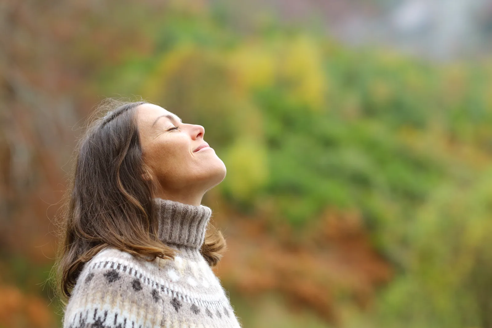 Frau atmet tief in der Natur ein