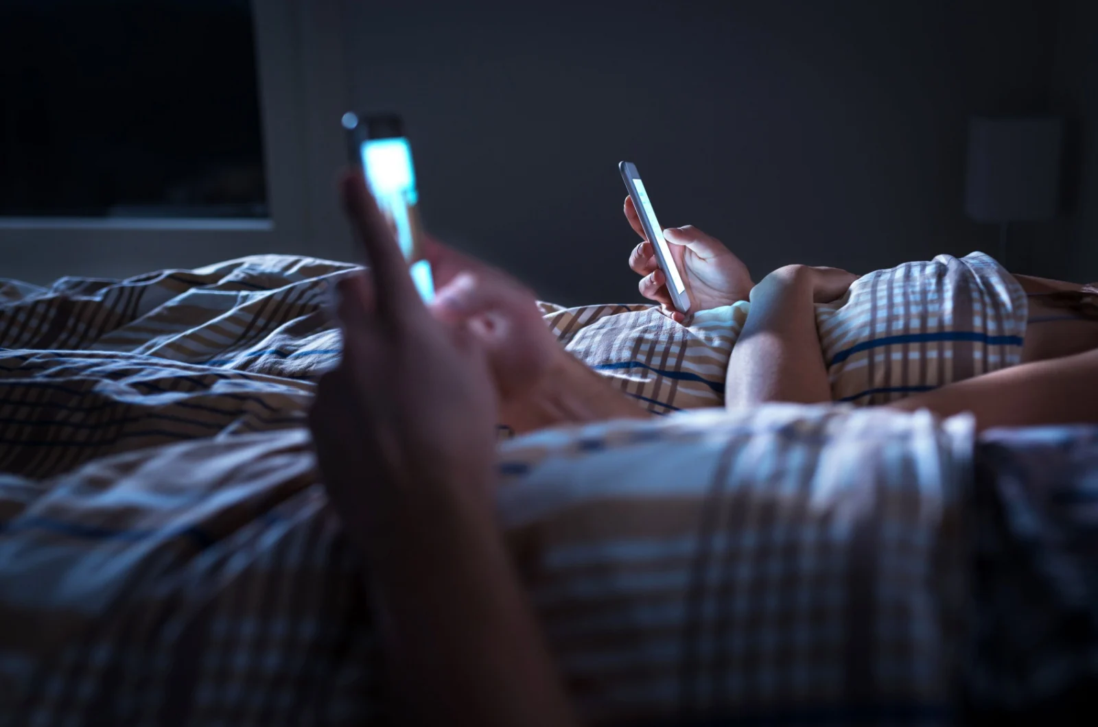 Paar mit Telefon im Bett Paar mit Telefon im Bett