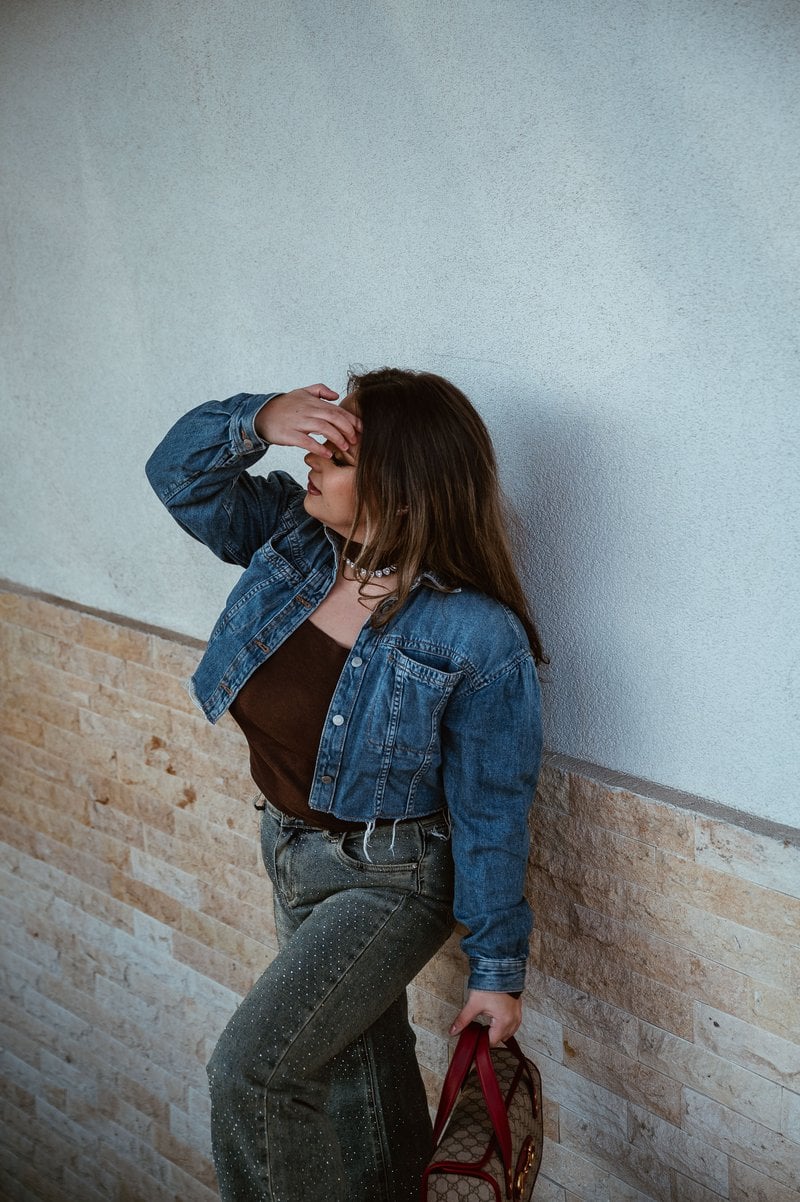Trendy Woman in Denim Jacket Standing Indoors &middot; Free Stock Photo