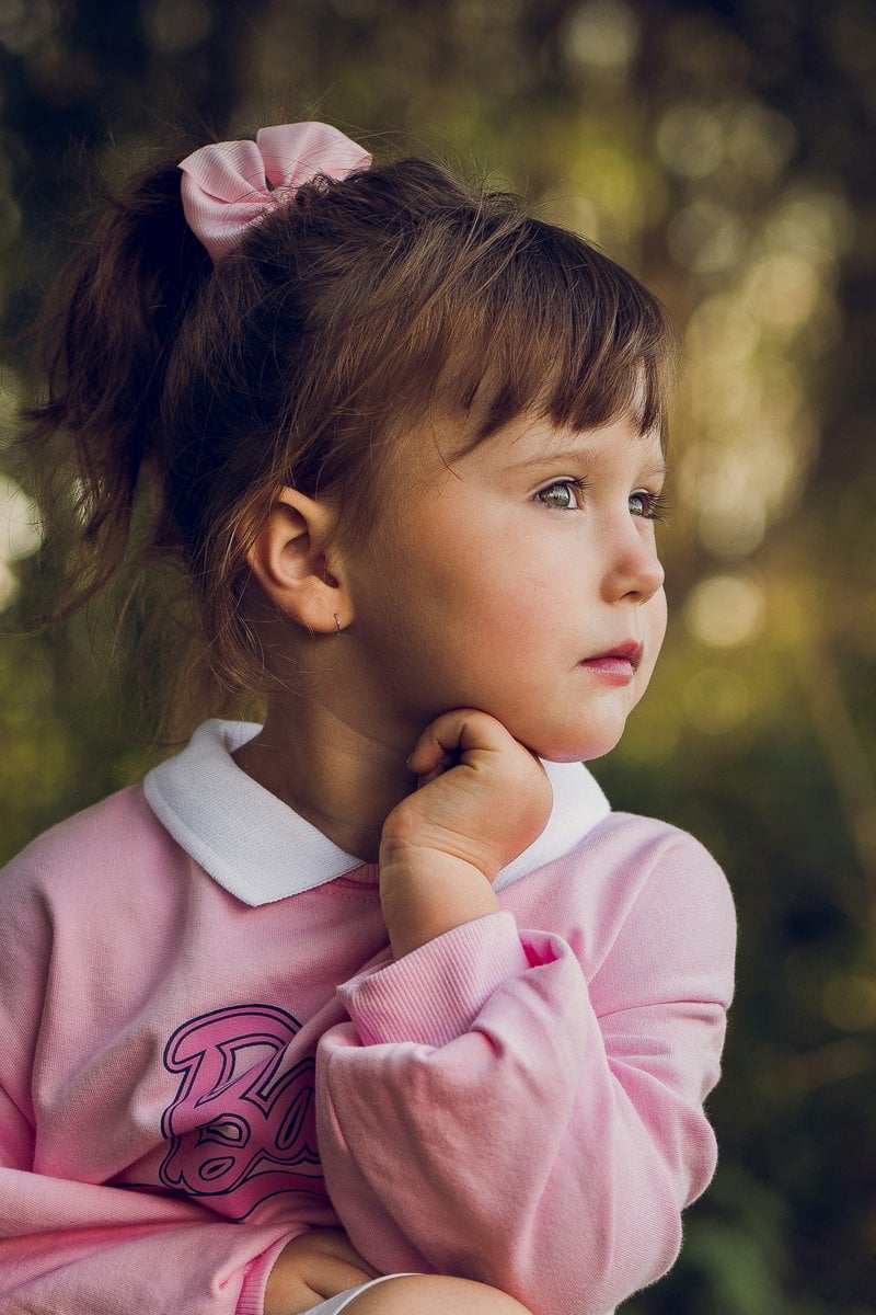 A little girl in a pink shirt is posing for a picture - Free ...