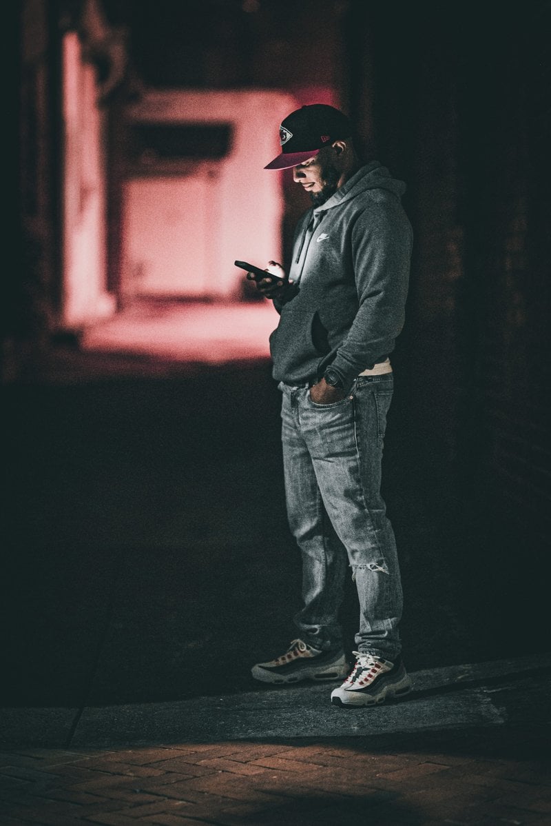 A man standing in the dark with a cell phone - Free Photo on Unsplash