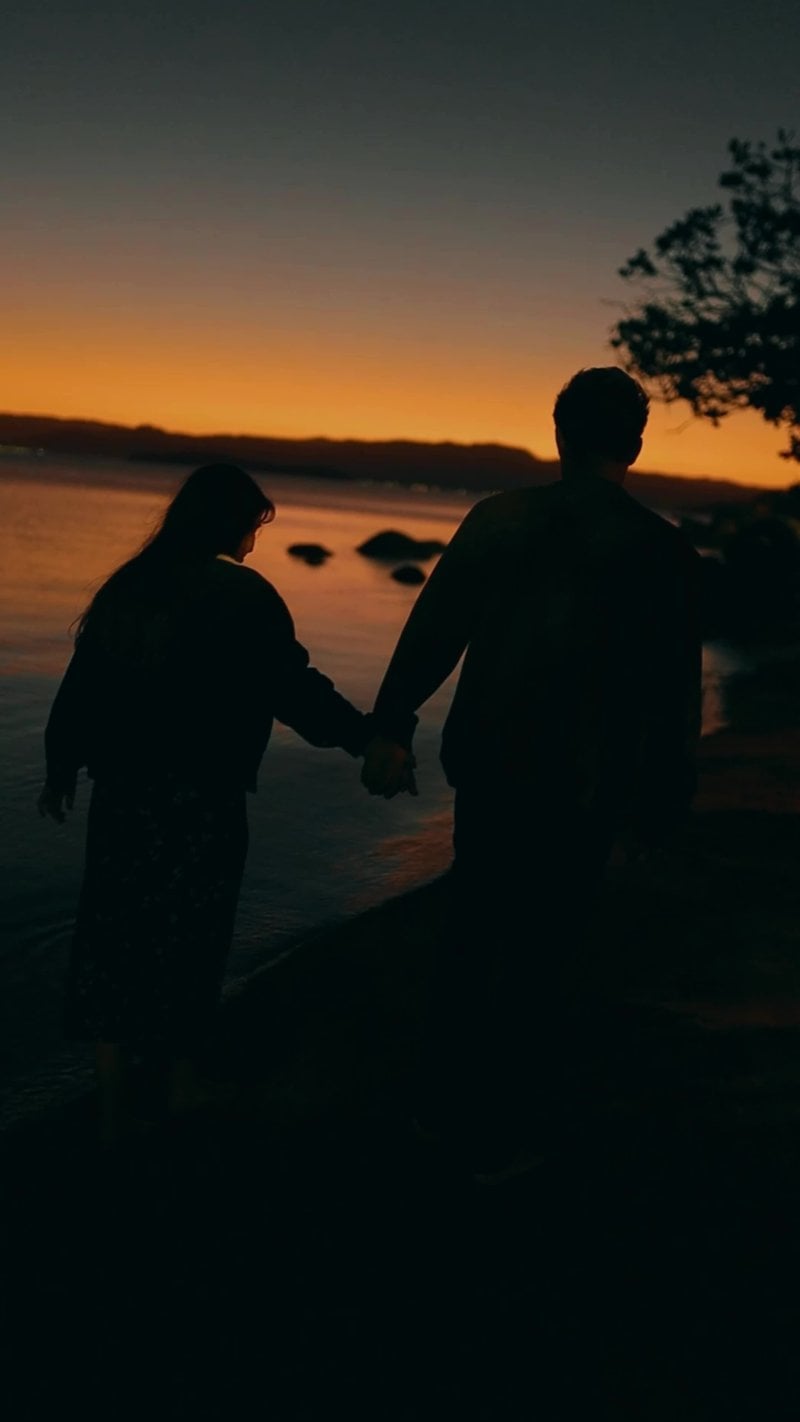 Couple Walking by Lakeside at Sunset