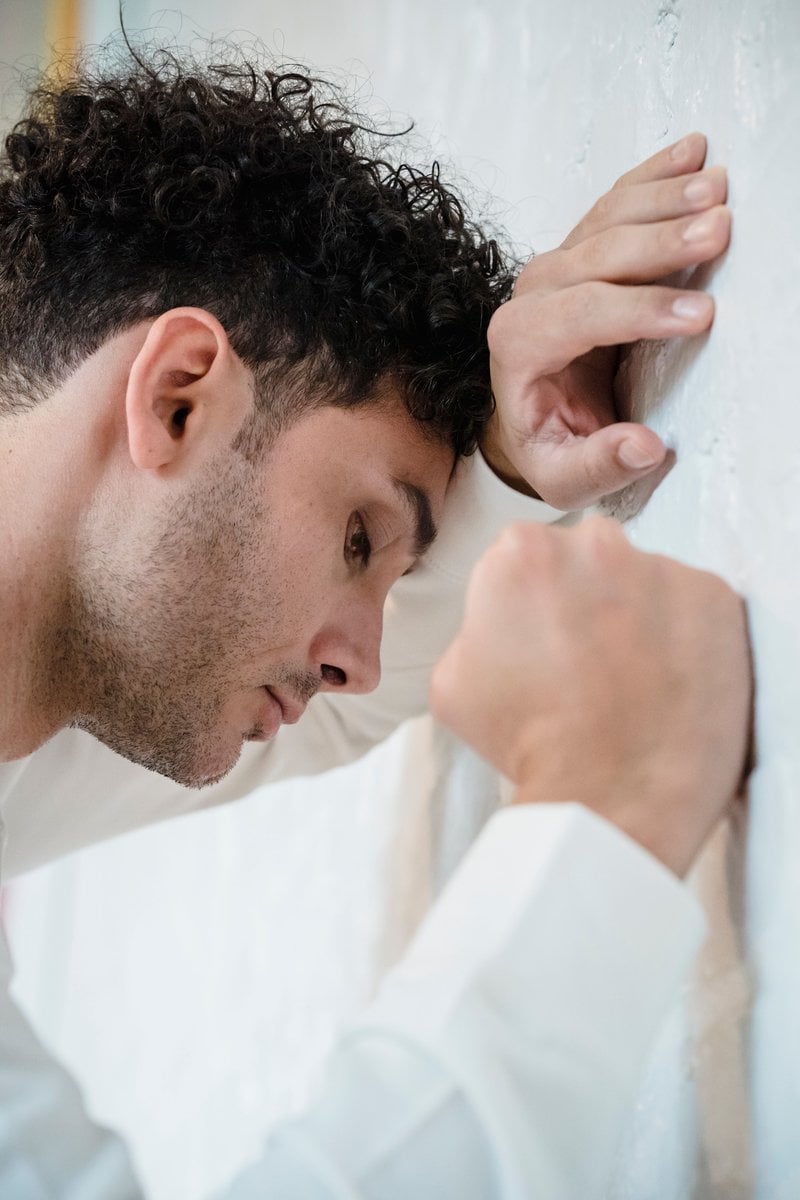 Man Leaning His Head on White Wall &middot; Free Stock Photo
